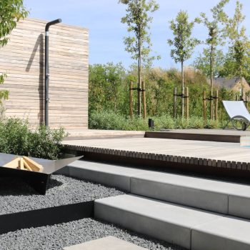 Moderne stijlvolle tuin ontworpen door Bart Tempels Tuinarchitectuur met trap naar het zwembad en buitendouche geplaatst voor een houten tuinwand.