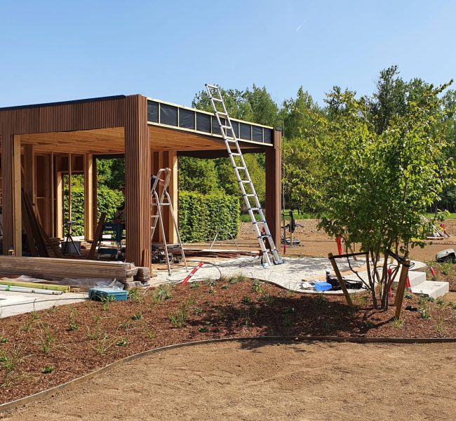Aanleg van een onderhoudsvriendelijke tuin en de plaatsing van een houten poolhouse.